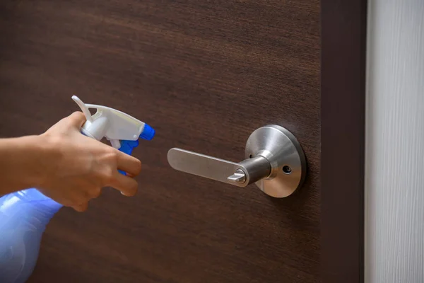 Use alcohols to clean a stainless door knob and wooden door due to Corona Virus (Covid-19) pandemic situation.