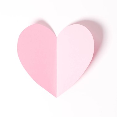 Beyaz kağıt üzerinde uçan kalp şeklinde kağıt elementler. Aşk ve Sevgililer Günü konsepti. Doğum günü tebrik kartı tasarımı.