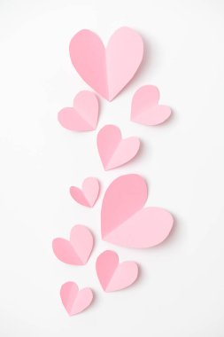 Beyaz kağıt üzerinde uçan kalp şeklinde kağıt elementler. Aşk ve Sevgililer Günü konsepti. Doğum günü tebrik kartı tasarımı.