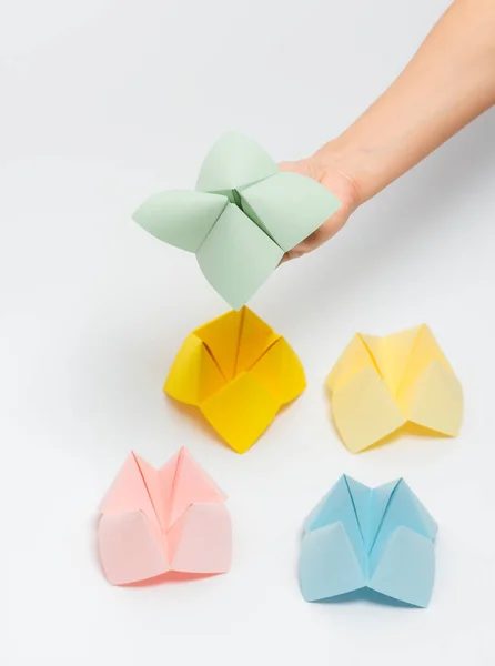 Close up of hand in a paper fortune teller isolated on white background.