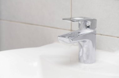 Coronavirus temizleme ve dezenfeksiyon önerisi yönergeleri: temiz ve dezenfekte edilmiş yüksek dokunaklı ev yüzeyleri. Evde banyo lavabosunda ellerini sabun ve sıcak suyla yıkamak.