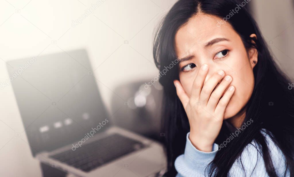 An asian woman getting anxiety and depression after checking stock market news about global pandemic. Lockdown mental health. Coronavirus outbreak