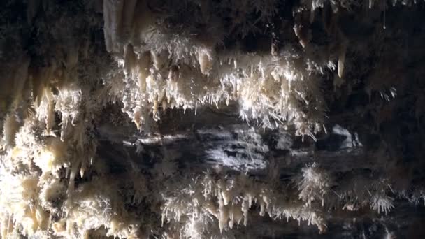Gyönyörű hatalmas barlang titokzatos fénnyel. Stalactites és sztalagmitok megvilágított gyönyörű változó fény. Óriási barlang a föld alatt. Földalatti királyság. Utazás a Föld középpontjába. — Stock videók