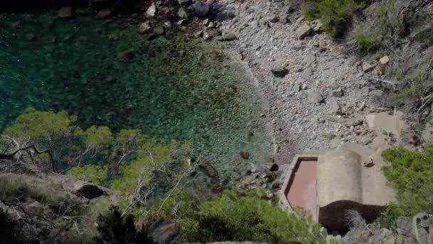 Vista dall'alto di una baia azzurra tra i pini. Pini che crescono sulle rocce. Pietre e acqua pulita blu e verde. Vista romantica . — Video Stock