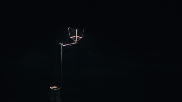 Storm waves hit the rocks at the stone embankment in the night. Vintage lantern in the foreground. Night view. Dramatic sea. Storm. — Stok video