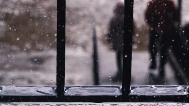 Des gouttes de pluie sur une vitre. Silhouettes d'un adulte et d'un enfant descendant les marches de la plage. Météo nuageuse et pluie. Calme et pacification . — Video