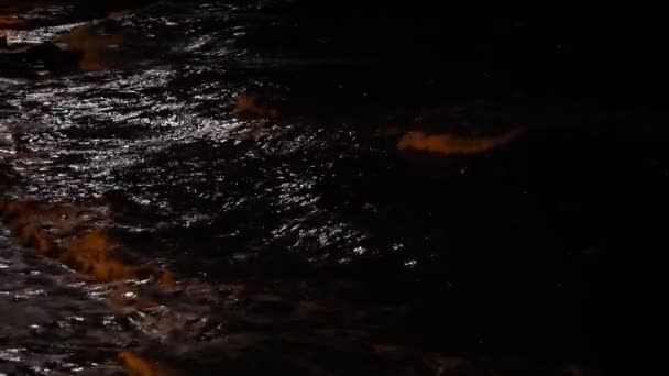Storm waves splashes in the night. Night view on the sea. Moonlight reflecting in the waves. Sparkling glare on the water surface. Dramatic sea. Storm. — Stockvideo