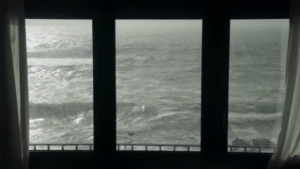 Vista del mare tempestoso dalla finestra. Guardando la tempesta. Grave mare infuriato. Grandi onde. Tempo piovoso ventoso. Vista dell'oceano drammatico dalla finestra . — Video Stock