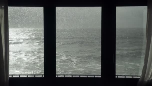 Vista do mar tempestuoso pela janela. A ver a tempestade. Mar em fúria severa. Ondas grandes. Tempo ventoso e chuvoso. Vista do oceano dramático da janela . — Vídeo de Stock