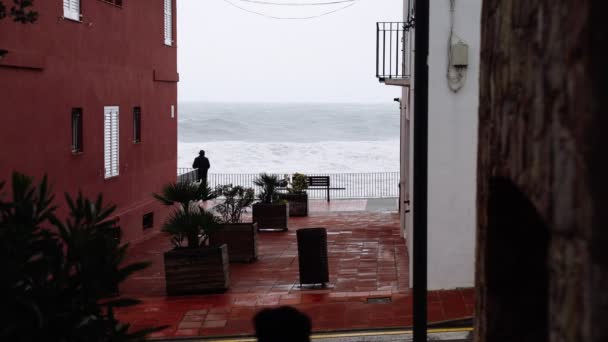 Vista del mar tormentoso desde las estrechas calles de un pequeño pueblo. Observando la tormenta. Pequeño pueblo durante una tormenta. Mar furioso severo. Grandes olas. Clima lluvioso ventoso. Vista del océano dramático . — Vídeos de Stock