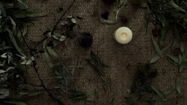 Flatlay με ψάθινο χαλί, ξηρά φυτά, και ένα αναμμένο κερί. Έσβησε το κερί. Ωραίος καπνός από ένα ξεθωριασμένο κερί. Βραδινές τελετές. Φυσικά χρώματα. Οικολογική αισθητική. Ανθοπωλείο. — Αρχείο Βίντεο