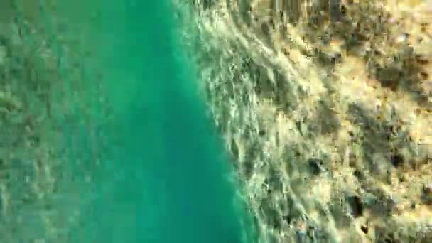 海底の砂底の閉鎖。水中撮影。水の表面から海岸の村のビュー。黄金の砂と澄んだ水。海底のサングレア。ダイビングカメラ. — ストック動画