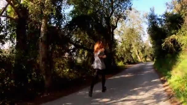 Mujer atlética joven corriendo en una mañana de primavera. Correr a lo largo de la carretera entre árboles y campos verdes. Deportes al aire libre. Estilo de vida saludable. Hermoso paisaje rural. Colores de primavera. Luz dorada. Correr. . — Vídeos de Stock