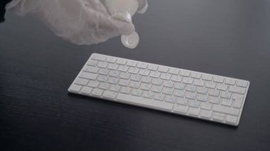 Dezenfekte. Virüs salgını için önlemler. Coronavirus karantinası. Lateks eldivenli eller, bilgisayar klavyesini dezenfektanla siler. Alkolle yüzey tedavisi. Evde kal. Salgın.