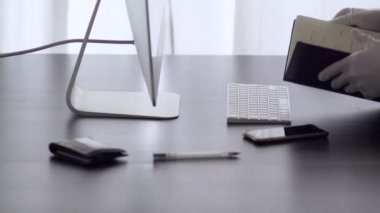 Bir adam evden çalışır. Lateks eldivenli bir adam not defterine not alır. Merkez ofis. Virüs salgını için önlemler. Coronavirus karantinası. Evde kal. Evden çalışıyorum. Salgın. Kendine dikkat et..