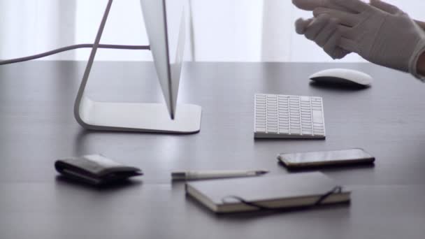 Um homem trabalha em casa. Mãos em luvas de látex estão digitando no teclado. Escritório. Precauções para a epidemia do vírus. Quarentena do Coronavírus. Fica em casa. Trabalho em casa. Surto. Fica em segurança. . — Vídeo de Stock