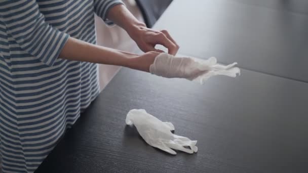 Desinfectie. Meisje doet latex handschoenen aan. Voorbereiding voor desinfectie. Voorzorgsmaatregelen voor de epidemie van het virus. Coronavirus quarantaine. Oppervlaktebehandeling met alcohol. Blijf thuis. Uitbraak. — Stockvideo