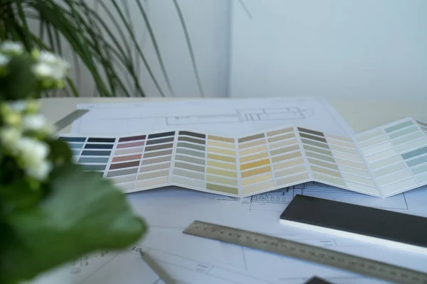 The interior designer selects wall paint samples. Designer at work. Architect desk. Decoration. Design project blueprints. Plans and drawings. Grey stone. Paint catalog. Decorative material. Flatlay — Stock Photo, Image