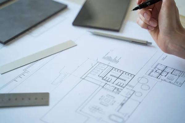 Interior designer working on drawings. Designer at work. Interior design. Architect at work. Decoration. Design project blueprints. Grey marble, stone. Decorative material. Stationery. Work from home.