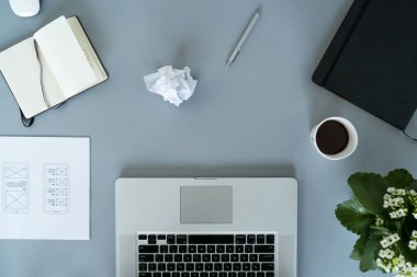 Web tasarımcısı iş başında. Grafik tasarımcısı. Mobil uygulama tasarımı. Tasarımcı masası. UX, UI tasarımı. Mobil uygulama taslaklarının küçük resimleri. Laptop, eskiz defteri, kalem ve kahve masanın üstünde..