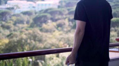 Evde spor var. Evde idman yapıyorum. Adam, plastik su şişesini bir su kemeri gibi kullanarak egzersiz yapıyor. El egzersizleri. Doğaçlama aletli spor. Evde kal. Karantina sırasında formda kalın. Pazılar, trisepsler. 