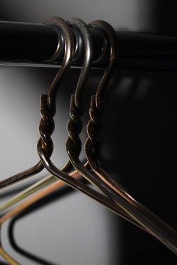 Empty iron hangers on a pipe.