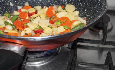 Kırmızı tavada sebze kızartma.