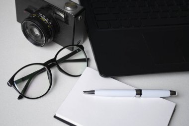 Desktop with a laptop. Safety glasses for working at a computer.And an old vintage camera in the background.