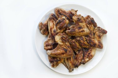 Barbekü tavuk kanadı, ızgara tavuk. Beyaz arka planda beyaz tabakta yemek. Tecrit altında..