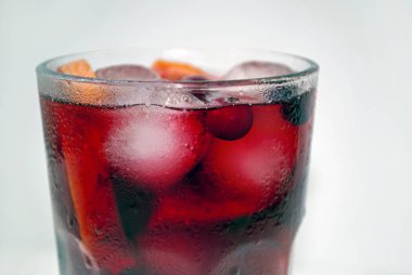 Yabanmersinli, limonlu ve portakallı ev yapımı soğuk limonata. Kızılcık buzlu çay. Limon dilimleri ve buzlu bir bardakta kokteyl. Yakın plan..