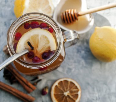 Yabanmersinli çay, limonlu bal ve mason kavanozunda baharat. Putty 'nin gri arka planında. Yakın çekim yap. Bal Çiçeği