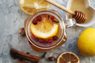 Yabanmersinli çay, limonlu bal ve mason kavanozunda baharat. Putty 'nin gri arka planında. Yakın çekim yap. Bal Çiçeği