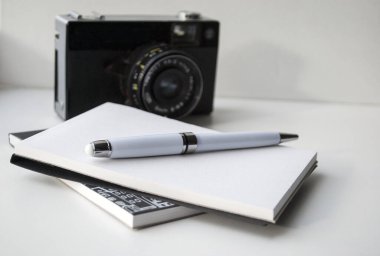 Not defteri, küçük nehir film retro kameraları. Beyaz arka planda. Siyah-beyaz kompozisyon.