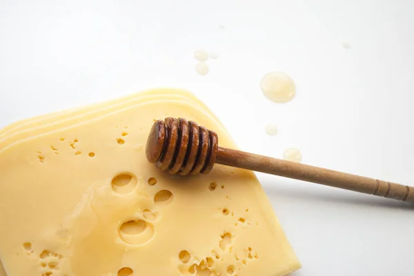 乳酪在白色上分离 切碎的奶酪 Maasdam是一种荷兰硬奶酪 有很大的开口 液体蜂蜜和蜂蜜调酒师 蜂蜜和奶酪的混合物 一滴滴蜂蜜 — 图库照片