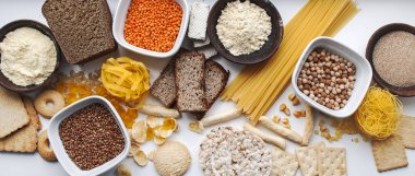 Glütensiz set. Glütensiz yemek. Çeşitli glütensiz makarna, ekmek, abur cubur ve un, üst manzara, pankart. Mısır taneleri.