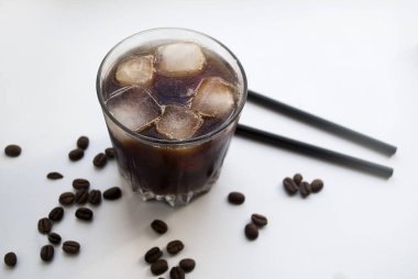 Yan manzara buzlu kahve, beyaz üzerine soğuk buzlu kahve. Koyu çikolata ve kahve taneleri..