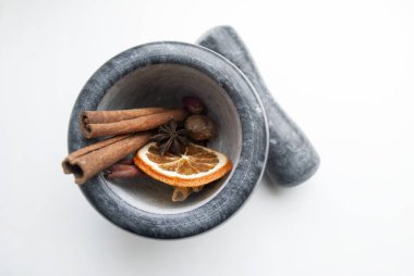 Baharatlı gri mermer havan: tarçın, anason, karanfil, portakal, hindistan cevizi.