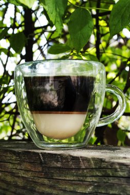 Cam bardaklarda yoğunlaştırılmış süt bulunan Vietnam kahvesi. Kalp şeklinde cam bardak ve çift cam, açık havada çift bardak. Geleneksel Vietnam kahvesi yapma yöntemi.