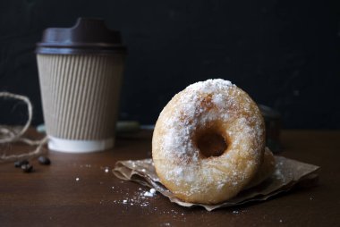 Pudra şekerli çörekler. Glütensiz ev yapımı pirinç unu çörekleri. Tahta bir masada kağıt bardakta kahve içmek için..