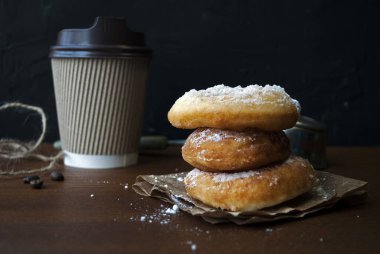 Pudra şekerli çörekler. Glütensiz ev yapımı pirinç unu çörekleri. Tahta bir masada kağıt bardakta kahve içmek için..