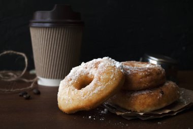 Pudra şekerli çörekler. Glütensiz ev yapımı pirinç unu çörekleri. Tahta bir masada kağıt bardakta kahve içmek için..