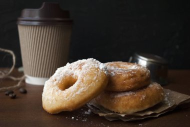 Pudra şekerli çörekler. Glütensiz ev yapımı pirinç unu çörekleri. Tahta bir masada kağıt bardakta kahve içmek için..