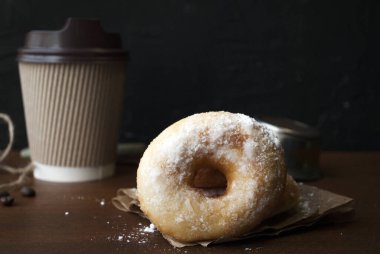 Pudra şekerli çörekler. Glütensiz ev yapımı pirinç unu çörekleri. Tahta bir masada kağıt bardakta kahve içmek için..