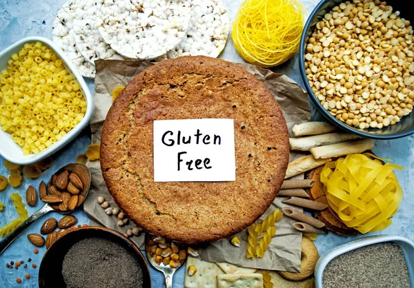 Set of various gluten free products and buckwheat bread in the center of the frame. Top view, flat composition, gluten free lettering.