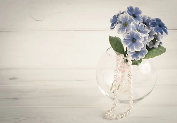 Bouquet de primevères en vase rond et collier perle femme — Photo