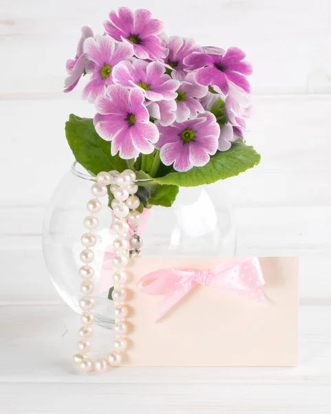 Bouquet de primevères en vase rond et collier perle femme — Photo