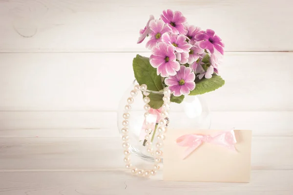 Bouquet de primevères en vase rond et collier perle femme — Photo