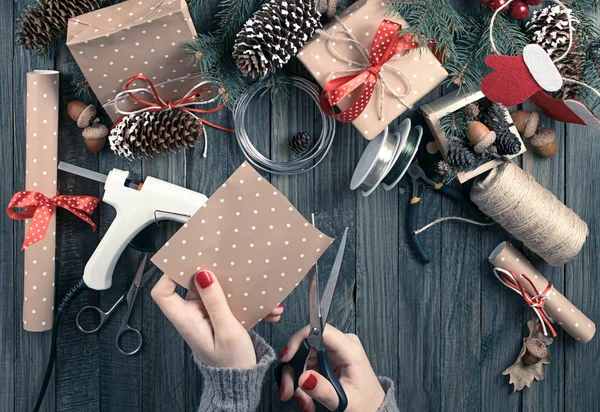 Christmas background with top view of woman's hands cutting pape — Stock Photo, Image