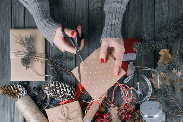 Vista dall'alto della donna mani taglio carta regalo per Natale prese — Foto Stock