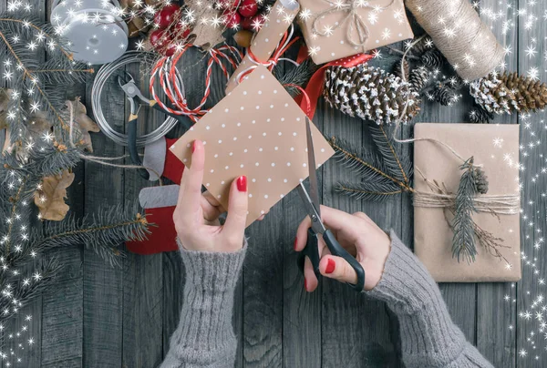 Vista dall'alto della donna mani taglio carta regalo per Natale prese — Foto Stock